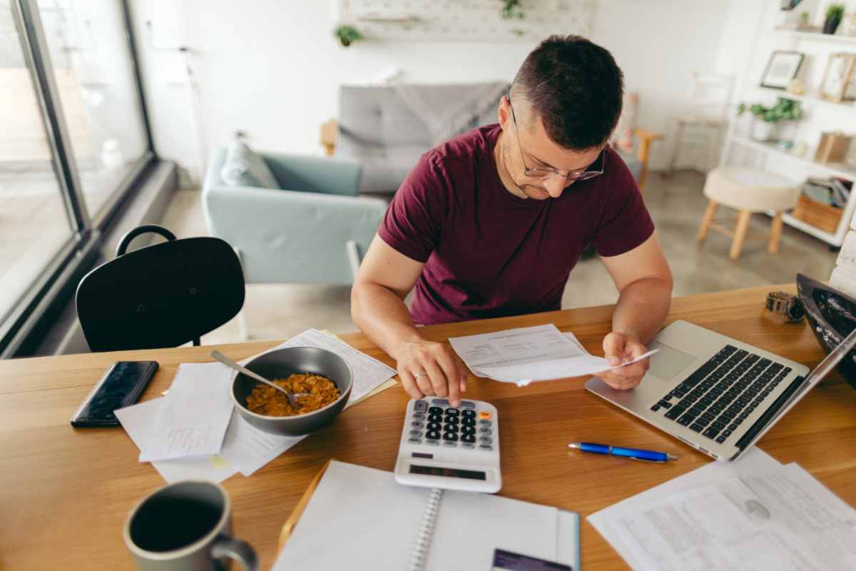 Uomo calcolatrice bollette